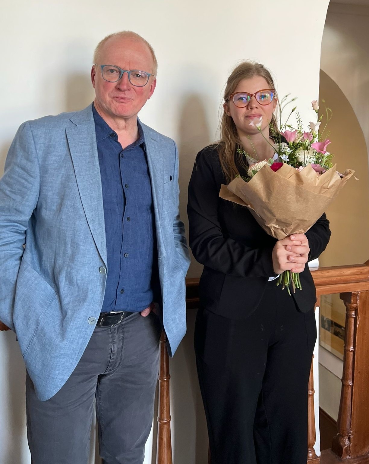 Das Foto zeigt Lena Senoner mit einem Blumenstrauß in der Hand kurz nach der erfolgreichen Verteidigung ihrer Dissertationsschrift an der Universität Potsdam am 1. Juni 2026. Neben ihr steht Professor Dr. André Steiner.