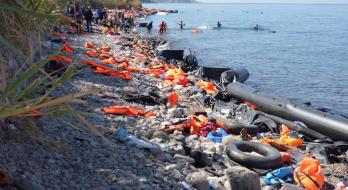 Foto: Rosa-Maria Rinkl: Blick auf die Nordküste von Lesbos zwischen den Ortschaften Molivos und Sykaminia. Der Küstenstreifen ist voll von Schwimmwesten und Flüchtlingsbooten. Die Aufnahme stammt vom September 2015, CC-BY-SA-4.0