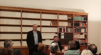 Preisverleihung Merkur-Preis 2025, in der Mitte sitzend der Preisträger Niklas Weber, davor sieht man Publikum.