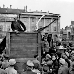 Wladimir Iljitsch Lenin bei einer Rede im Mai 1920. Aus dem Bild wurden Leo Trotzki und Lew Kamenew später auf Anordnung von Josef Stalin herausretuschiert (Foto: Grigori Petrowitsch Goldstein / Gemeinfrei).